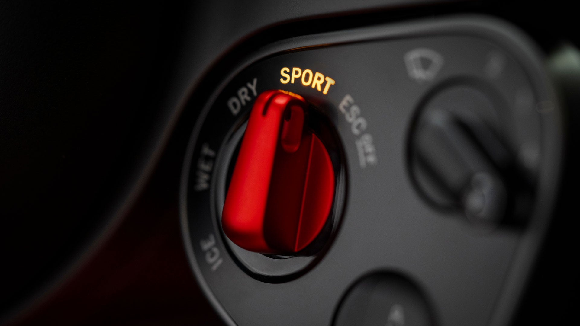 Rear view of a red Ferrari Luce sports car in darkness, with bright red circular taillights.
